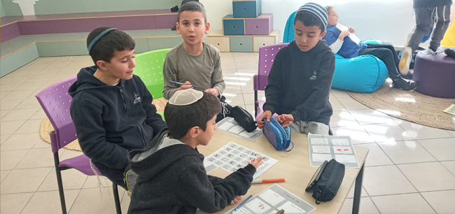 ילדים יושבים ומשחקים ונהנים בבית ספר חמדת שקד בהפסקה 